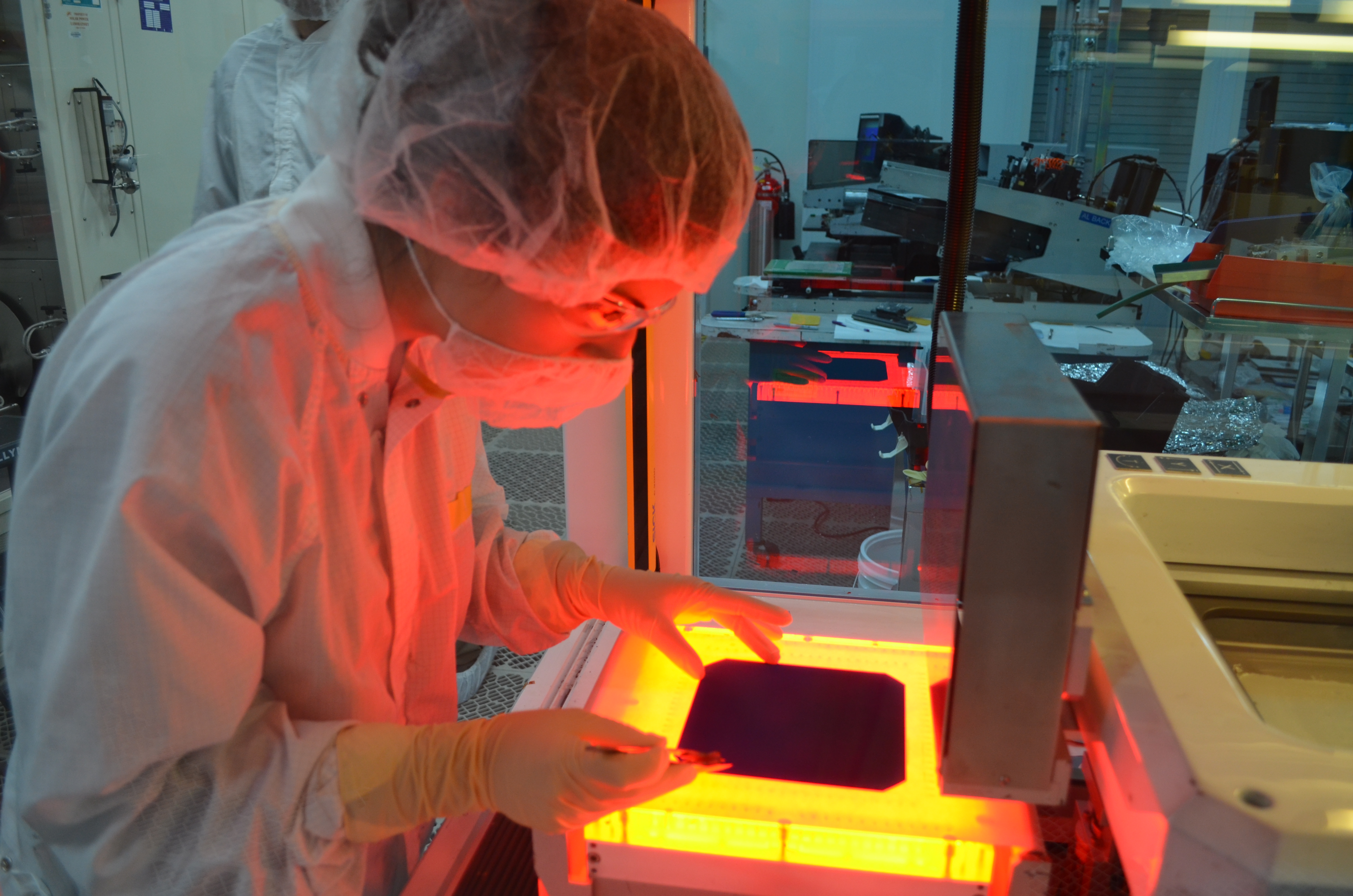 QESST student that attended Solar Cell 101 places a cell to be screen-printed. This machine automatically applies the top fingers and buss bars.